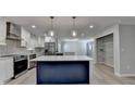 Modern kitchen with stainless steel appliances, stylish island and white cabinets with custom backsplash at 780 N Ola Rd, Mcdonough, GA 30252