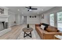 Sunlit living room with hardwood flooring, stylish fireplace, modern ceiling fan, and comfortable seating at 780 N Ola Rd, Mcdonough, GA 30252