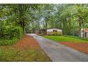Long paved driveway leading to a home nestled among lush trees at 2700 Brook Park Way, Doraville, GA 30340