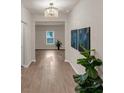 Inviting entryway featuring modern decor, wood floors, a stylish chandelier, and an open floor plan at 436 Vermeer Ct, Locust Grove, GA 30248