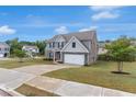 Two-story home with a brick and siding exterior, a spacious driveway, and a well-maintained lawn at 436 Vermeer Ct, Locust Grove, GA 30248