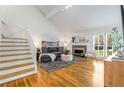 Bright living room features vaulted ceiling, hardwood floors, fireplace, and staircase at 1420 Defoors Nw Dr, Atlanta, GA 30318