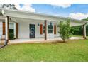 Inviting front porch with decorative wood columns, security door, and manicured landscaping at 7307 Banks Mill Rd, Douglasville, GA 30135