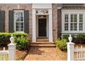 Close up of the home's front door showing brick walkway and meticulous landscaping at 1128 Bellewood Sq, Dunwoody, GA 30338