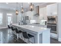 Bright kitchen featuring a stainless steel appliance suite, modern white cabinets, and an island with bar stool seating at 1382 Doublegate Ne Dr, Atlanta, GA 30319
