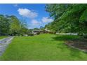 Expansive front yard featuring a well-manicured lawn and mature trees, leading up to a beautiful brick home at 204 Mt Moriah Rd, Auburn, GA 30011