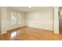 Light-filled living room with hardwood floors, white wainscoting, and large windows at 300 Maple Grove Ct, Canton, GA 30114