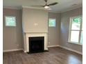 Cozy living room with a fireplace, neutral walls, and hardwood floors at 3032 Farm Tract Trl, Woodstock, GA 30189