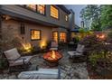 Cozy backyard patio with a fire pit, comfortable seating, and mature trees at twilight at 3167 Blairhill Ct, Atlanta, GA 30340