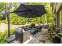 Inviting outdoor patio with comfortable seating, a cantilevered umbrella, and lush greenery at 3167 Blairhill Ct, Atlanta, GA 30340