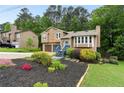 Two-story house with a well-manicured lawn and colorful flower beds surrounding the front, creating a welcoming curb appeal at 4849 Chapelle Ct, Marietta, GA 30066