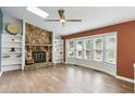 Spacious living room featuring a stone fireplace, built-in shelving, large windows, and hardwood floors for a cozy atmosphere at 4849 Chapelle Ct, Marietta, GA 30066