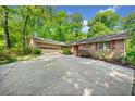 Beautiful single-story brick home boasts a spacious driveway and attached garage, surrounded by lush greenery and mature trees at 659 Pleasant Hill Nw Rd, Conyers, GA 30012