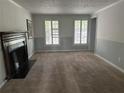 Spacious living room with large windows, neutral carpeting, and a traditional fireplace at 150 N Pond Ct, Roswell, GA 30076