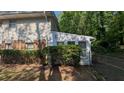Home's exterior featuring a sunroom addition and mature landscaping at 1349 Cedar Heights Dr, Stone Mountain, GA 30083