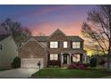 Charming brick home at sunset featuring a well-manicured lawn and a cozy front porch, perfect for relaxing at 2710 Irwin Ct, Cumming, GA 30041
