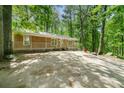 View of the home with siding, covered porch, surrounded by large mature trees at 507 Lakeshore Dr, Stockbridge, GA 30281