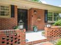 Cozy front porch featuring brick detail, lantern decor, and a decorative wrought iron security door at 2178 Tanglewood Rd, Decatur, GA 30033