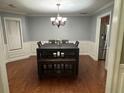 Dining room features wainscoting, modern light fixture and dark wood table at 3511 Autumn Farm Ter, Buford, GA 30519