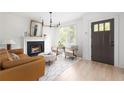 Bright living room with fireplace, modern chandelier, hardwood floors, and stylish furniture at 134 Woodlawn Ave, Decatur, GA 30030