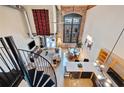 A spiral staircase overlooks this home's open living and kitchen space with exposed brick and tall windows at 170 Boulevard Se # E414, Atlanta, GA 30312