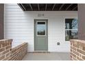 Front entrance of home, featuring a green door, brick accents, and white siding at 2215 Nena Way # 20, Tucker, GA 30084