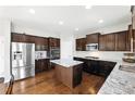 Modern kitchen boasts stainless steel appliances, granite countertops, and a center island at 345 Varenna Ln, Sugar Hill, GA 30518