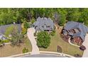 Expansive aerial view of the property showing the house, driveway, mature landscaping, and neighborhood at 5885 Wild Azalea Cv, Sugar Hill, GA 30518