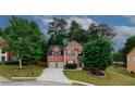Charming two-story brick home with manicured lawn and driveway, framed by lush trees in a neighborhood setting at 1425 Bridle Path Dr, Lawrenceville, GA 30045