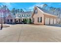 Side view of a brick home featuring a three-car garage and large driveway at 239 Trail Nw Rd, Marietta, GA 30064