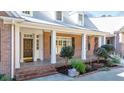 View of the home's front porch with brick detail, white columns, and a black front door at 239 Trail Nw Rd, Marietta, GA 30064