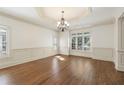 Formal dining room with hardwood floors, elegant chandelier, and large windows with plantation shutters at 2480 Flint Creek Dr, Cumming, GA 30041