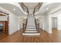 Grand foyer featuring a striking curved staircase, hardwood floors, and elegant trim at 2480 Flint Creek Dr, Cumming, GA 30041
