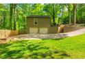 Two-car garage, stairs leading to a deck, driveway, and well-manicured lawn surrounding the property at 3925 Rock Mill Pkwy, Marietta, GA 30062