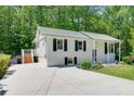 Side view of a white brick home featuring a long driveway leading to a wooden deck and shed at 3990 Admiral Dr, Chamblee, GA 30341