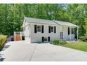 Well-maintained home features white brick, black shutters, concrete driveway, and a small deck at 3990 Admiral Dr, Chamblee, GA 30341