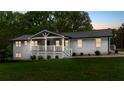 Beautifully landscaped white brick home featuring a cozy, covered front porch at 9680 Ephesus Church Rd, Villa Rica, GA 30180