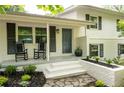 Inviting front porch with rocking chairs and manicured landscaping with dark shutters and a painted door at 3383 Campbell Se Rd, Smyrna, GA 30080