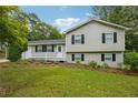 Charming two-story home with a white porch and surrounded by mature trees and lush landscaping at 798 Bankshire Dr, Suwanee, GA 30024