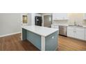 Modern kitchen with center island, stainless steel dishwasher, and white cabinets for ample storage at 798 Bankshire Dr, Suwanee, GA 30024