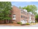 Charming brick townhome featuring black shutters, one car garage, and mature trees at 2301 Waters Edge Trl, Roswell, GA 30075