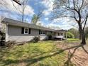 A quaint one-story home with gray siding and a cozy covered porch nestled in a wooded area at 326 Old Farm Road, Woodstock, GA 30188