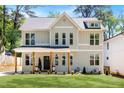 Inviting two-story home featuring a welcoming front porch and well-manicured lawn at 2553 Creekwood Ter, Decatur, GA 30030