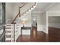 Inviting foyer featuring a staircase, hardwood floors, and an entry table with views into adjacent living spaces at 2870 Abbottswell Dr, Alpharetta, GA 30022