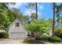 Charming home featuring a two-car garage, manicured lawn, and mature landscaping at 6250 Bannerhorn Run, Alpharetta, GA 30005