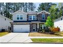 Beautiful two-story home featuring a stone facade, manicured lawn, and a two-car garage at 660 Stately Dr, Woodstock, GA 30188