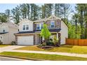 Charming two-story home with a stone facade, well-maintained lawn, and attached two-car garage at 660 Stately Dr, Woodstock, GA 30188