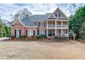 Charming two-story brick home with a double balcony, complemented by a well-maintained lawn and traditional design at 2930 Aquitania Ln, Cumming, GA 30040