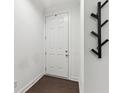 Bright entryway with a white door, dark wood floors, and a modern coat rack for a welcoming space at 4259 Baden Aly, Duluth, GA 30097