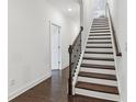 Elegant staircase with wood treads, an iron railing, and natural light creates a striking architectural feature at 4259 Baden Aly, Duluth, GA 30097